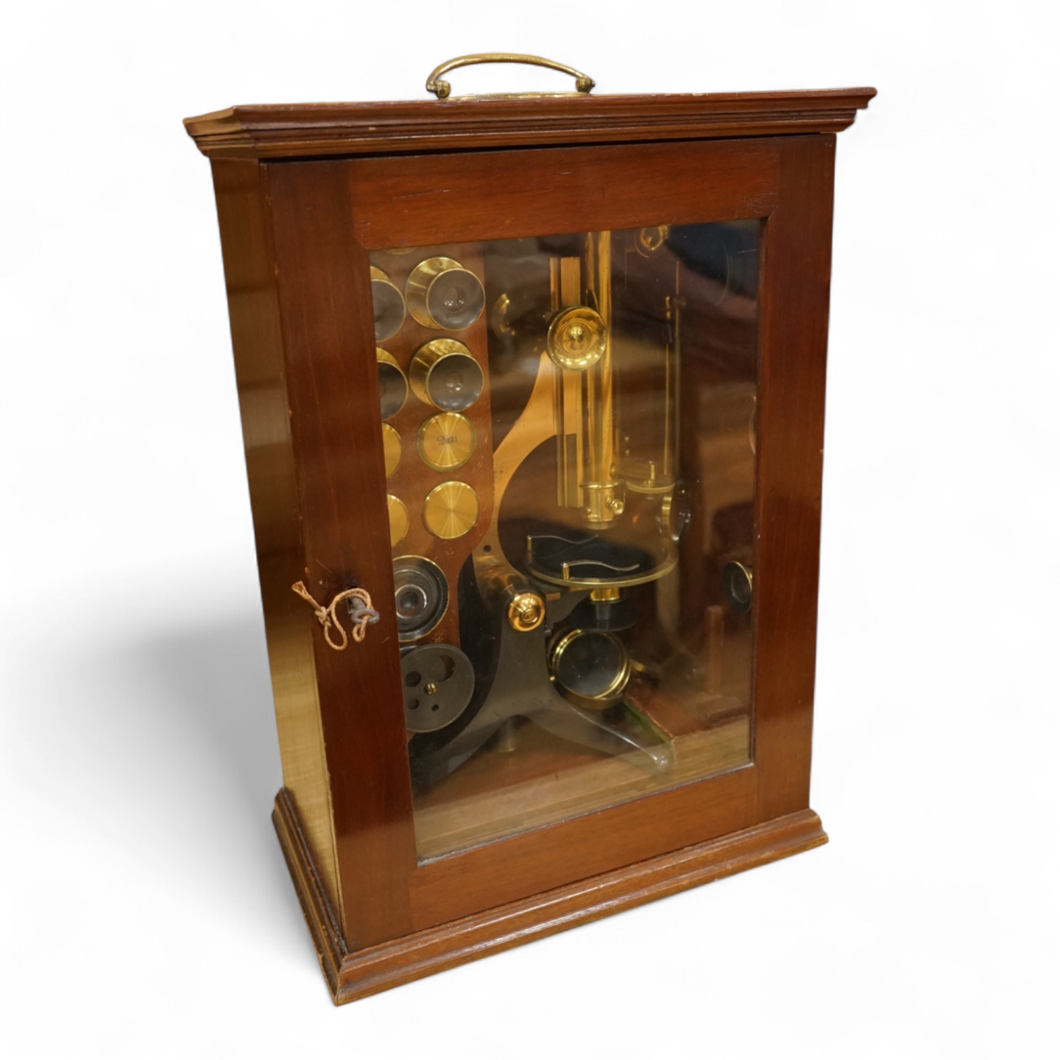 A Victorian binocular brass microscope, unsigned, in a fitted, glass fronted case with a good selection of alternative lenses and accessories, all in fitted compartments, plus three integral drawers to hold microscope sl
